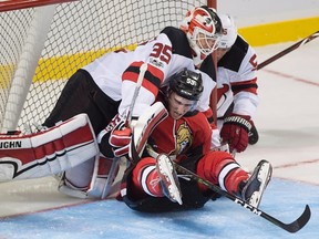 Ottawa Senators' Alex Formenton is knocked into New Jersey Devils goaltender Cory Schneider during NHL pre-season action in Summerside, P.E.I., on Sept. 25, 2017. (THE CANADIAN PRESS/Andrew Vaughan)