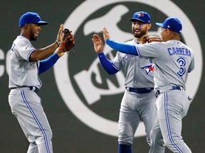 Toronto Blue Jays' Teoscar Hernandez, left, Ezequiel Carrera and Kevin Pillar celebrate after defeating the Boston Red Sox 6-4 during a baseball game in Boston on Sept. 25, 2017. (AP Photo/Michael Dwyer)