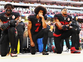 (L-R) Eli Harold #58, Colin Kaepernick #7, and Eric Reid #35 of the San Francisco 49ers kneel in protest during the national anthem prior to their NFL game against the Arizona Cardinals at Levi's Stadium on October 6, 2016 in Santa Clara, California. (Photo by Thearon W. Henderson/Getty Images)  Arizona Cardinals v San Francisco 49ers