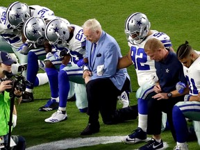In this Monday, Sept. 25, 2017 file photo, the Dallas Cowboys, led by owner Jerry Jones, center, take a knee prior to the national anthem prior to an NFL football game against the Arizona Cardinals, in Glendale, Ariz. (AP Photo/Matt York, File)