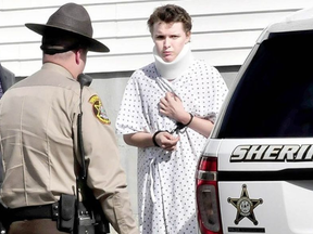 Wearing a hospital gown and neck brace from injuries sustained on Tuesday, suspect Zachary Wittke is led into a Franklin County Sheriff transport vehicle following a hearing on charges of eluding police, passing a roadblock and aggravated criminal mischief. DAVID LEAMING / KENNEBEC JOURNAL