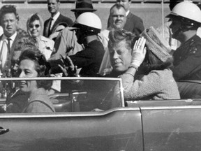 In this Nov. 22, 1963 file photo, President John F. Kennedy waves from his car in a motorcade approximately one minute before he was shot in Dallas. Riding with Kennedy are First Lady Jacqueline Kennedy, right, Nellie Connally, second from left, and her husband, Texas Gov. John Connally, far left. The National Archives has until Oct. 26, 2017, to disclose the remaining files related to Kennedy's assassination, unless President Donald Trump intervenes. (AP Photo/Jim Altgens, File)