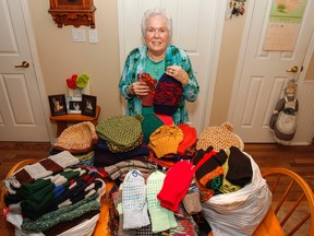 Lois Robeson-Stephens shows off the 150 knitted items that cover her kitchen table in Kingston, Ont. on Friday September 22, 2017. The items that she knitted, along with her daughter, will be donated to the hospital in Whitehorse in honour of Canada 150. Julia McKay/The Whig-Standard/Postmedia Network