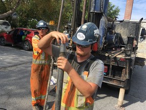 Elliot Ferguson/The Whig-Standard
Luke McClellan, right, and Mike Turnbull of GET Drilling Ltd. of Napanee take core samples from under the Byron Lot on Queen Street as part of the city’s testing for the potential building of a parking garage on the site.