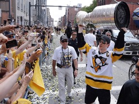Pittsburgh Penguins' Sidney Crosby hoists the Stanley Cup for fans during the team's Stanley Cup NHL hockey victory parade June 14, 2017, in Pittsburgh. (THE CANADIAN PRESS/AP/Gene J. Puskar)
