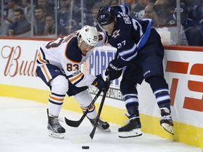 Edmonton Oilers defenceman Matthew Benning, left, and Winnipeg Jets forward Nikolaj Ehlers fight for the puck during NHL pre-season action in Winnipeg on Wednesday, Sept. 20, 2017. John Woods/THE CANADIAN PRESS