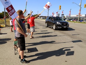 Unifor workers on strike at Cami in Ingersoll cast shadows on a warm day. (MIKE HENSEN, The London Free Press)