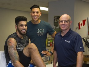 London Lightning?s Julian Boyd shows off a scar with physiotherapist Vince Fung and surgeon Dr. Bob Litchfield at the Fowler Kennedy Sports Medicine Clinic in London this week. They each did their part to take Boyd from a possible career-ending injury to ready to play as soon as January. (DEREK RUTTAN, The London Free Press)