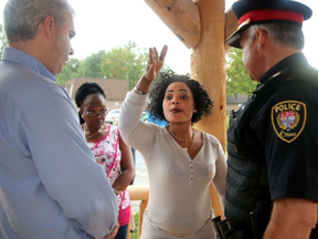 Mother of five Apolina Mahamba complains to Chief Charles Bordeleau (right) and city councillor Riley Brockington about the need for more security. About 100 Caldwell Avenue area residents showed up for a rally Wednesday afternoon following the shooting death of a young man in that neighbourhood last week. Many of the residents complained they need more security in the area. JULIE OLIVER /POSTMEDIA