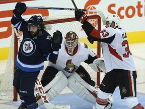 Ottawa Senators goaltender Mike Condon looks between Winnipeg Jets forward Mathieu Perreault and defenceman Fredrik Claesson during NHL pre-season action in Winnipeg on Sept. 27, 2017. (Kevin King/Winnipeg Sun/Postmedia Network)