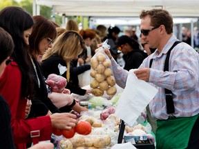 The Holden Colony Produce booth does brisk business during the first farmer's market in Federal Building Plaza at the Alberta Legislature, in Edmonton Wednesday Sept. 27, 2017. Photo by David Bloom