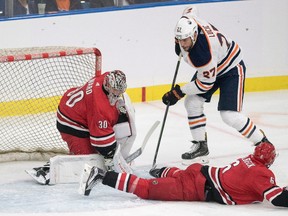 Edmonton Oilers forward Milan Lucic sends the puck though the crease as Carolina Hurricanes goalie Cam Ward attempts a save during the first period of NHL pre-season action in Saskatoon, Sask. Wednesday, September 27, 2017.