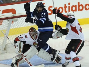 Jets forward Mathieu Perreault jumps in front of Senators goaltender Mike Condon as Fredrik Claesson defends the crease during NHL pre-season action last night at Bell MTS Place. The Jets won 5-3. (Kevin King/Winnipeg Sun)