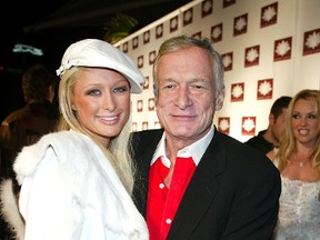 Paris Hilton (L) greets playboy Hugh Hefner at the grand opening of the club/restaurant White Lotus on March 7, 2003 in Hollywood, California. (Photo by Kevin Winter/Getty Images)