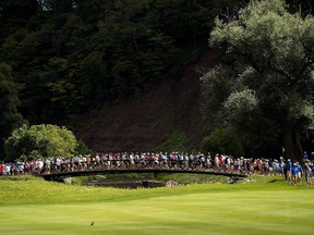 Spectators cross the bridge between the 13th and 14th holes during the Canadian Open golf tournament at Glen Abbey golf club, in Oakville, Ont., on Saturday, July 29, 2017. (THE CANADIAN PRESS/Nathan Denette)