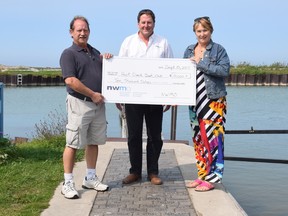 The Nuclear Waste Management Organization recently donated $10,000 to assist with the restoration of the Point Clark harbour and boat launch. L-R: Point Clark Boat Club president Paul Grominsky, received the donation from NWMO's Paul Austin and Marie Wilson.
