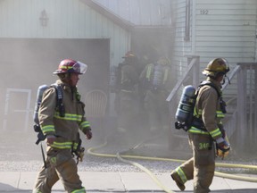 Kingston firefighters walk past a house at 192 Concession St. where fire caused significant damage to a house in Kingston, Ont. onMonday, Sept. 25, 2017. 
Elliot Ferguson/The Whig-Standard/Postmedia Network