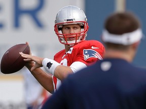 New England Patriots quarterback Tom Brady, left, winds up for a pass as offensive coordinator Josh McDaniels stands nearby during NFL practice on Sept. 27, 2017. (AP Photo/Steven Senne)