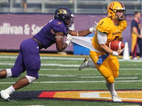 Queen's Gaels Nate Hobbs escapes the grasp of Golden Hawks Robbie Smith during the second half of Ontario University Athletics action at Richardson Stadium in Kingston on Sept. 16. Wilfrid Laurier defeated Queen's University 40-17. (Steph Crosier/The Whig-Standard)