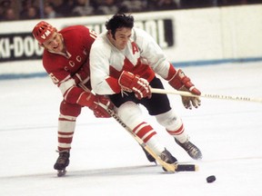 Team Canada centre Phil Esposito battles a Soviet opponent during the 1972 Summit Series. (NHL.com)