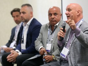 From left, Alfonso Balassone of EllisDon, Adam Carapella of Tricar and Shmuel Farhi of Farhi Holdings listen as Sean Ford of Dancor Construction, speaks at the Commercial Emerge Conference 2017 in London. (MIKE HENSEN, The London Free Press)