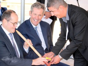 Pascal Leroy (left), Roquette VP of pea and new proteins business line, smokes from a pipe while Eric Pashe (right), Dakota Tipi councillor, lights the tobacco and Manitoba premiere Brian Pallister (middle), watches on with amusement during a ceremonial pipe smoking event to kick off this afternoon's Roquette groundbreaking ceremony in Portage la Prairie. (Brian Oliver/Postmedia Network)