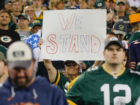 Fans hold up signs before an NFL football game between the Green Bay Packers and the Chicago Bears on Sept. 28, 2017. (AP Photo/Mike Roemer)