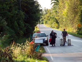 This file photo taken on August 20, 2017 shows a cab dropping off a couple of asylum seekers at the U.S./Canada border near Champlain, New York. (GEOFF ROBINS/Getty Images)