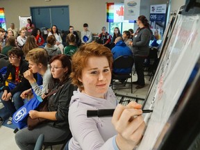 Luke Hendry/The Intelligencer 
Belleville's Shawnee Wannamaker takes notes during one of many group discussions at the Youth-2-Youth Summit Friday in the Tyendinaga Recreation Hall in Melrose. People ages 14 to 25 gathered to discuss solutions for a wide range of issues, including mental health, poverty, the environment and diversity. Organizers plan to discuss results with area politicians and possibly develop an action report or youth committee for further work.