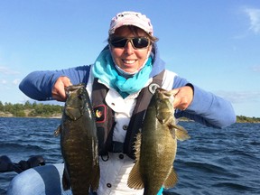 Columnist Frank Clark's wife, Jackie, shows off a couple big bronzebacks from Georgian Bay. The couple always have their auto inflatable PFDs when out on the water. Photo supplied