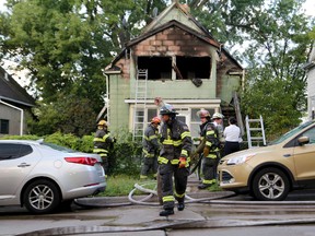 Firefighters look over the scene of a duplex fire that gutted the upstairs and left two seriously burned Thursday, Sept. 28, 2017, in Minneapolis. (David Joles/Star Tribune via AP)