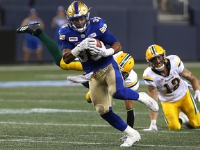 Winnipeg Blue Bombers running back Andrew Harris sheds a pair of Edmonton Eskimos tacklers during CFL action in Winnipeg on Thurs., Aug. 17, 2017.