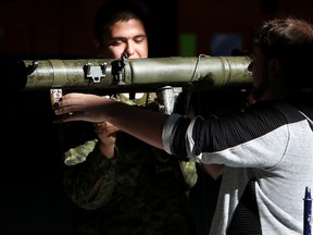 Private Ryan Carter (left) shows Belleville resident, Mitchell Johnston, one of the displays during a visit to the Belleville Armouries on Saturday September 30, 2017 in Belleville, Ont. The building was open to the public on Saturday as part of a Canadian Army (CA) Reserve Open House, which took place at all CA Armouries and reserve units across Canada. The Open House showcased the work reservists do on behalf of Canada and featured interactive displays and activities. Under Strong, Secure, Engaged: Canada’s Defence Policy, the government of Canada has committed to increasing the size of the Reserve Force to 30,000 (an increase of 1,500) and to reduce the length of time it takes for an individual to join the Reserve Force to approximately 30 days. Tim Miller/Belleville Intelligencer/Postmedia Network
