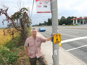 Steve Anderson stands next to the sign for what he says is a dangerous bus stop on Eagleson Road.