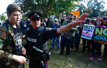 City police escort a protestor during a White Supremacy demonstration on Saturday September 30, 2017 Confederation Square in Peterborough, Ont. CLIFFORD SKARSTEDT/PETERBOROUGH EXAMINER/POSTMEDIA NETWORK