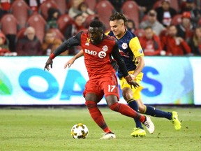 Toronto FC's Jozy Altidore (left) takes possession of the ball ahead of New York Red Bulls' Aaron Long on Saturday. (THE CANADIAN PRESS)
