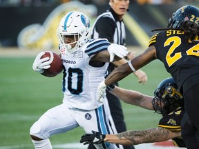 Argonauts running back Martese Jackson (left) avoids being tackled by Tiger-Cats defensive back Courtney Stephen (22) during first-half CFL action in Hamilton, Ont., on Saturday, Sept. 30, 2017. (Peter Power/The Canadian Press)