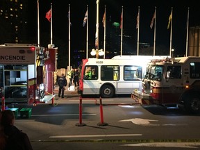 An OC Transpo bus is surrounded by emergency vehicles near Elgin and Rideau on Saturday night.