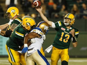 Edmonton's quarterback Mike Reilly (13) throws under pressure from Winnipeg's defence during the first half of a CFL football game between the Edmonton Eskimos and the Winnipeg Blue Bombers at Commonwealth Stadium in Edmonton, Alberta on Saturday, September 30, 2017.