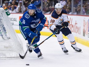 Vancouver Canucks' Alex Biega (55) skates with the puck while being pursued by Edmonton Oilers' Jesse Puljujarvi, of Sweden, during the first period of a preseason NHL hockey game in Vancouver, B.C., on Saturday September 30, 2017.