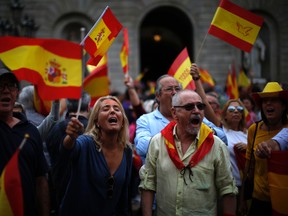 People wave Spanish flags while demonstrating against Catalonia's planned referendum on secession in Barcelona Saturday, Sept. 30 2017. The planned referendum is due to be held Sunday by the pro-independence Catalan government but Spain's government calls the vote illegal, since it violates the constitution, and the country's Constitutional Court has ordered it suspended. (AP Photo/Manu Fernandez)