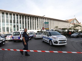 A French police officer cordons off the access to Marseille 's main train station Sunday, Oct. 1, 2017 in Marseille, southern France. French police have warned people to avoid Marseille's main train station following a knife attack that made at least one dead. (AP Photo/Claude Paris)