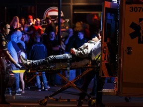 An injured person is loaded on to an ambulance outside the The Pint bar on 109 Street near Jasper Avenue after Edmonton Police Service officers arrested a man nearby who attacked a police officer outside of an Edmonton Eskimos game in an apparent terrorist attack in Edmonton, Alberta on Sunday, October 1, 2017. Ian Kucerak / Postmedia