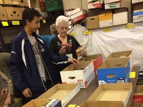 Volunteers Gabriel Portugal and Sharon Ray sort through food following a door-to-door food blitz for Helping Hand Food Bank in Tillsonburg on Saturday. (HEATHER RIVERS/SENTINEL-REVIEW)