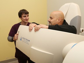 Jurrien Bentley, left, nuclear medicine technologist supervisor in the nuclear medicine department at MyHealth Centre, demonstrates a D-Spect heart scan device with the help of cardiac technologist Mauro Greco on Friday. (John Lappa/Sudbury Star)