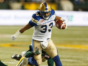 Edmonton's Kenny Ladler (37) tackles Winnipeg's Andrew Harris (33) during the first half of a CFL football game between the Edmonton Eskimos and the Winnipeg Blue Bombers at Commonwealth Stadium in Edmonton, Alberta on Saturday, Sept. 30, 2017. (Ian Kucerak/Postmedia)