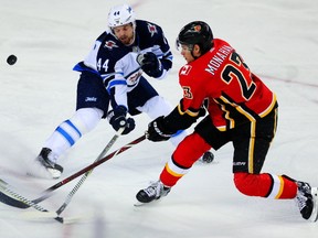 Calgary Flames Sean Monahan shoots the puck while being defended by Josh Morrissey of the Winnipeg Jets during NHL pre-season hockey at the Scotiabank Saddledome in Calgary on Saturday, September 30, 2017. (Al Charest/Postmedia Network)
