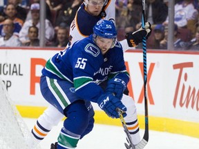 Vancouver Canucks' Alex Biega (55) reaches for the puck in front of Edmonton Oilers' Jesse Puljujarvi, of Sweden, during the first period of a preseason NHL hockey game in Vancouver, B.C., on Saturday September 30, 2017.