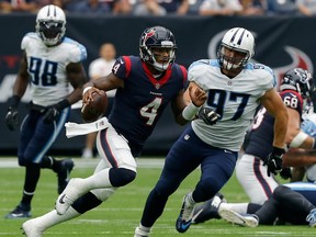 Texans quarterback Deshaun Watson runs the ball against the Titans on Sunday. The 22-year-old rookie threw for four TDs. (Getty Images)