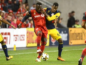 Toronto FC's Jozy Altidore, left, fights for the ball against New York Red Bulls' Michael Murillo during first half MLS soccer action Saturday September 30, 2017 in Toronto. THE CANADIAN PRESS/Jon Blacker